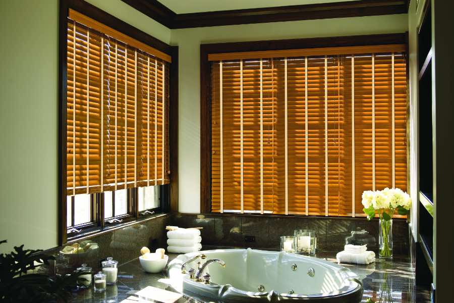 Premium quality blinds are always a stylish accent in your San Jose home. Brown wood blinds on large windows in a green bathroom