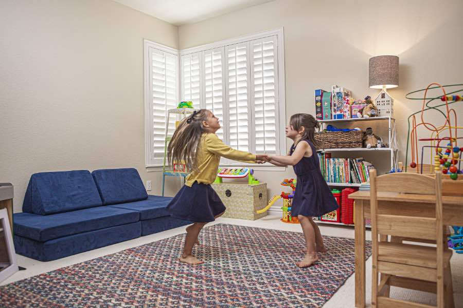 Choose Polywood shutters for durable, kid-friendly great room window treatments in San Jose. Polywood shutters on multiple windows in a sitting area