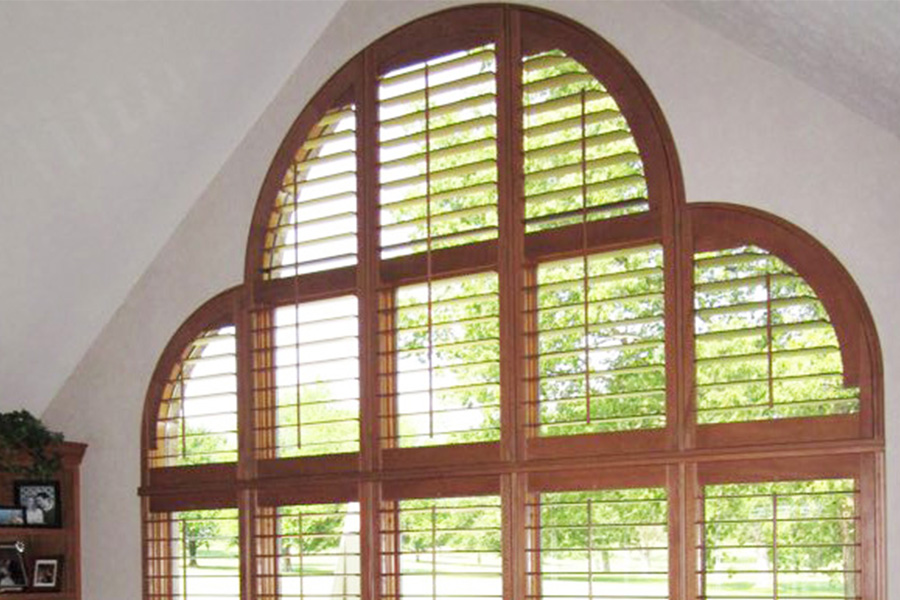 Palladian windows also look amazing with hardwood Ovation shutters. Ovation shutters with a special shaped arched window in a living room.