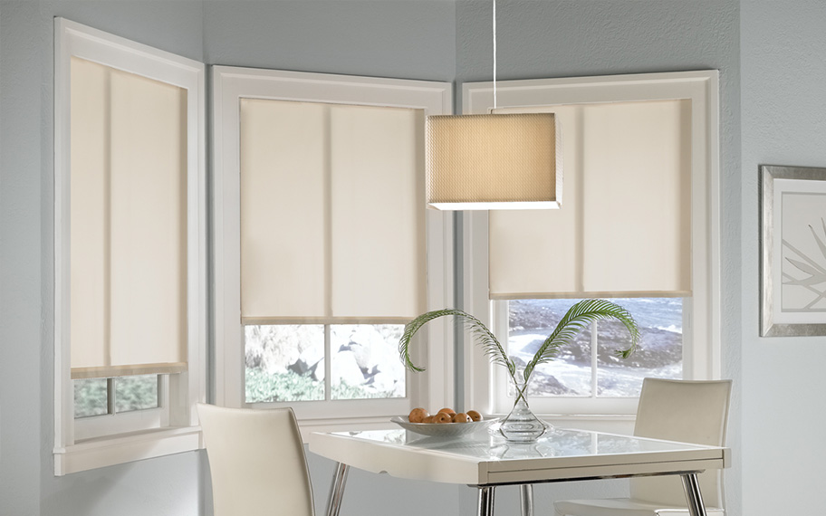 Quality window shades meet modern interior design at Sunburst Shutters San Jose. Roller shades in modern white kitchen.